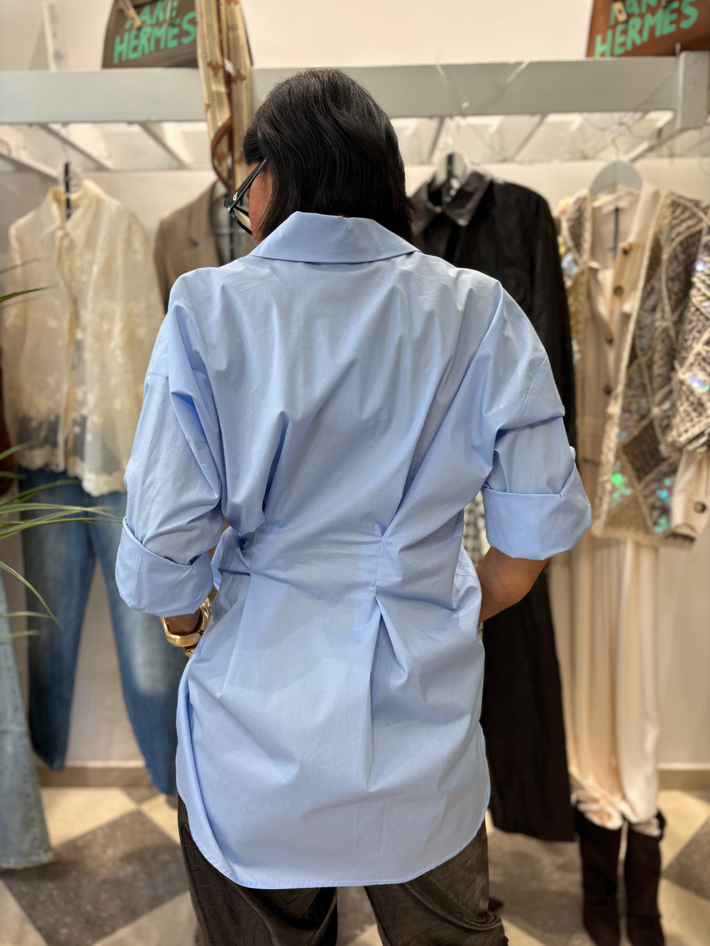 Camicia azzurra con drappeggio laterale