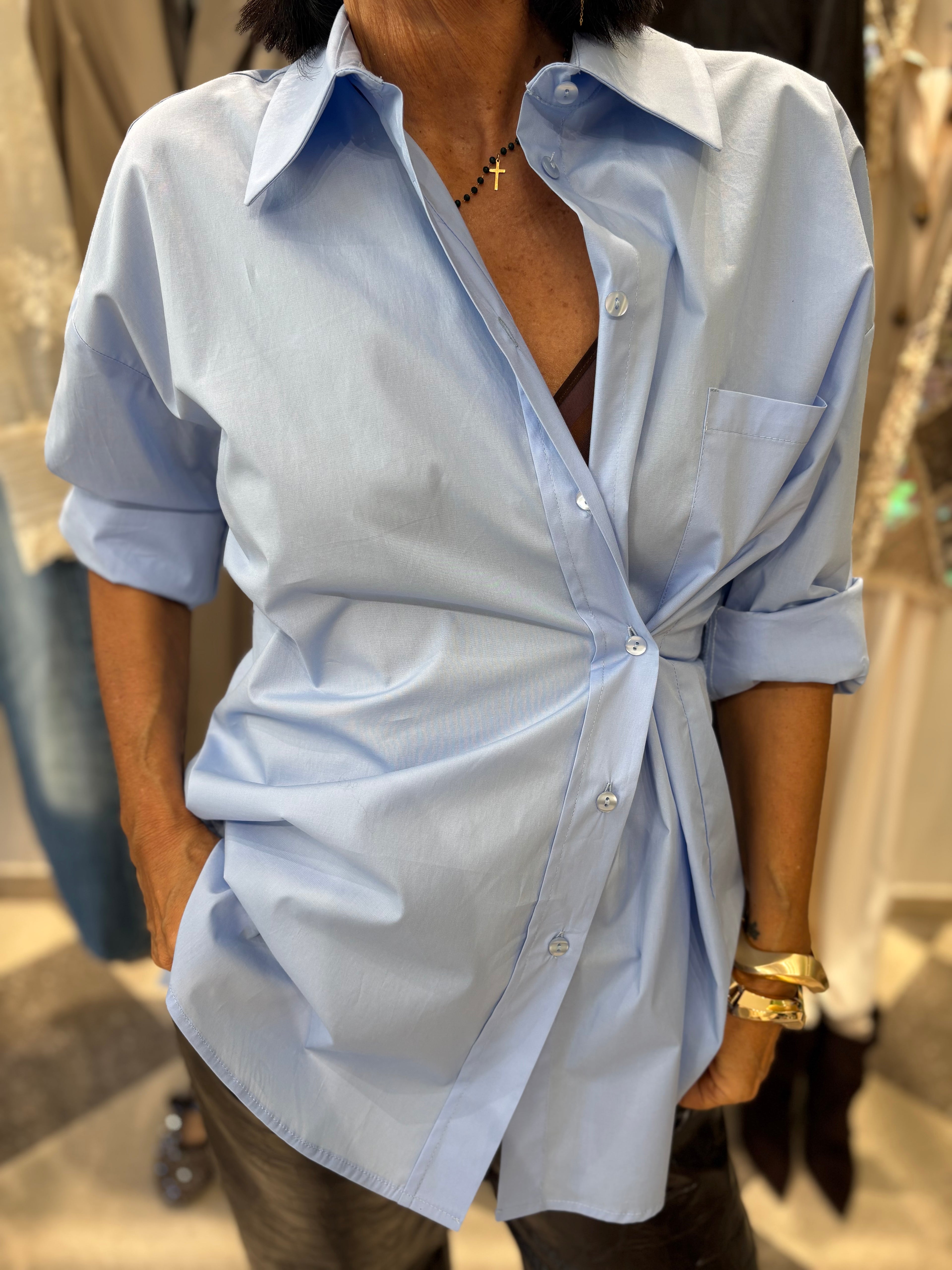 Camicia azzurra con drappeggio laterale