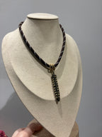 Collana con cordoncino intrecciato e pendente con borchie metalliche